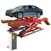 A blue sedan is elevated on a red car lift, specifically the AMGO Hydraulics DX-12A Scissor Alignment Lift with a 12,000 lbs capacity, while the control panel is visible on the left side.