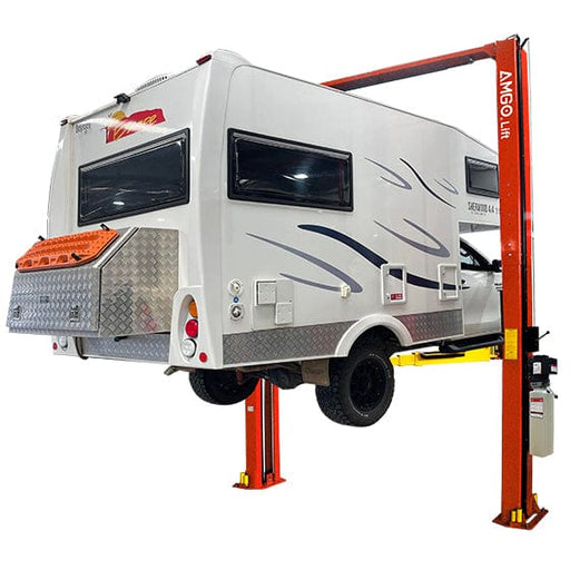 A motorhome is elevated on an AMGO Hydraulics OH-12 12,000 lbs 2 Post Lift, revealing its underside and rear.