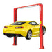 A yellow car is elevated on an AMGO Hydraulics AMGO OH-9 9,000 lbs red 2 Post Lift, showing the vehicle from the rear.