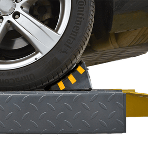 Rubber wheel chock placed against a vehicle tire on the lift runway
