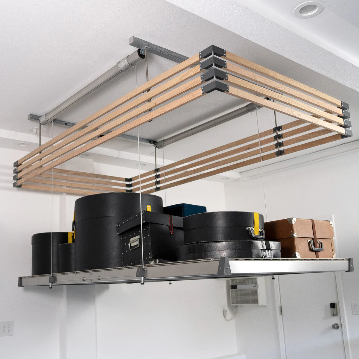Hardwood slat fence enclosing a loaded ceiling-mounted overhead garage storage platform