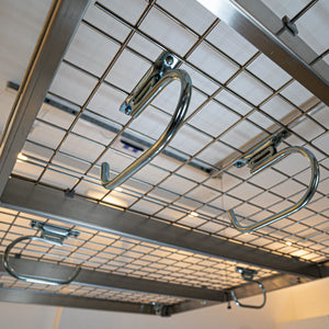 Overhead garage storage rack with hooks installed near the ceiling of an empty garage