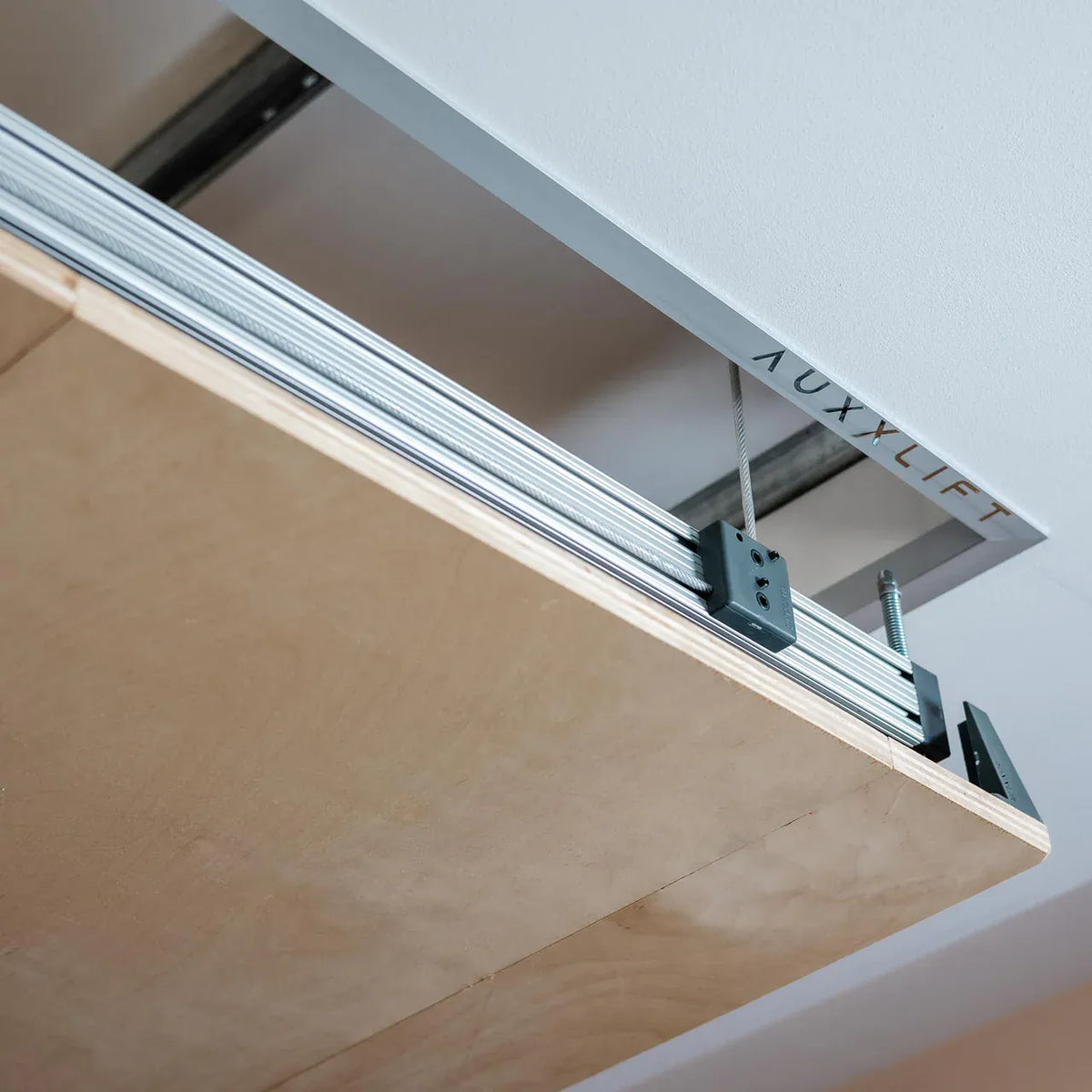 Close-up of a lifting cable attached to the platform's aluminum T-slot frame bracket