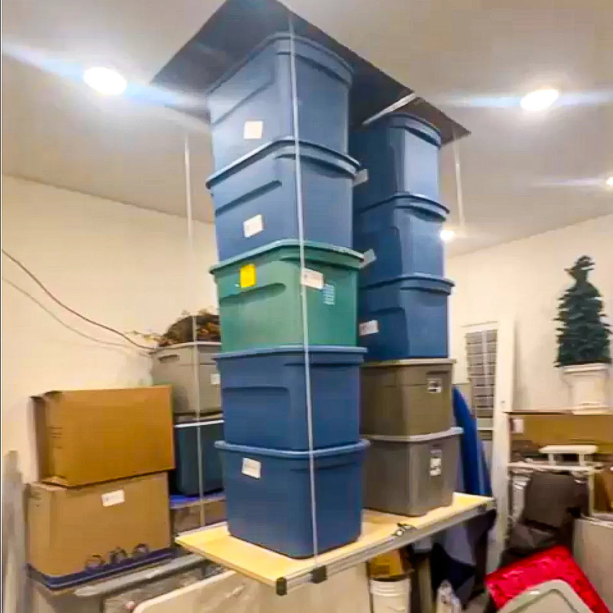 Attic-Lift raising a tall stack of storage totes toward the ceiling opening