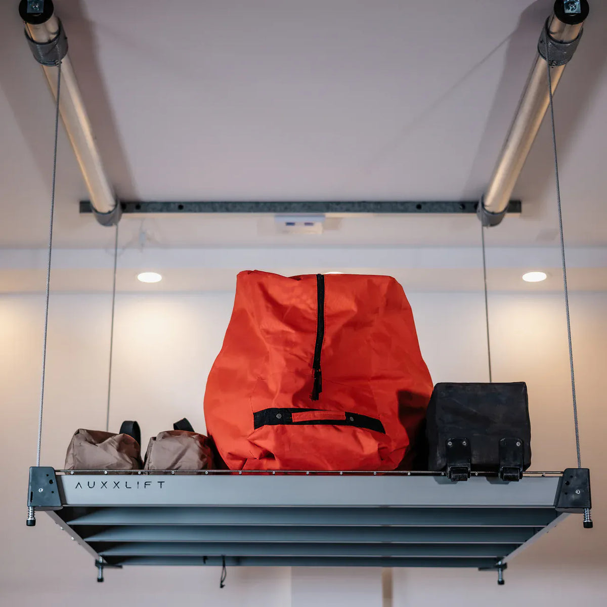 Close-up of the AUXXLIFT-branded side rail on a loaded ceiling storage platform