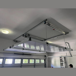 Auxx-Lift platform mounted above garage doors with a clear protective cover over the deck
