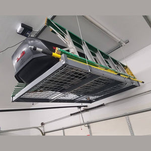 Auxx-Lift platform mounted near a garage door holding an extension ladder and a cargo box