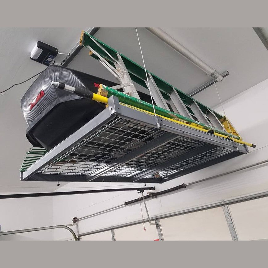 Auxx-Lift platform mounted near a garage door holding an extension ladder and a cargo box