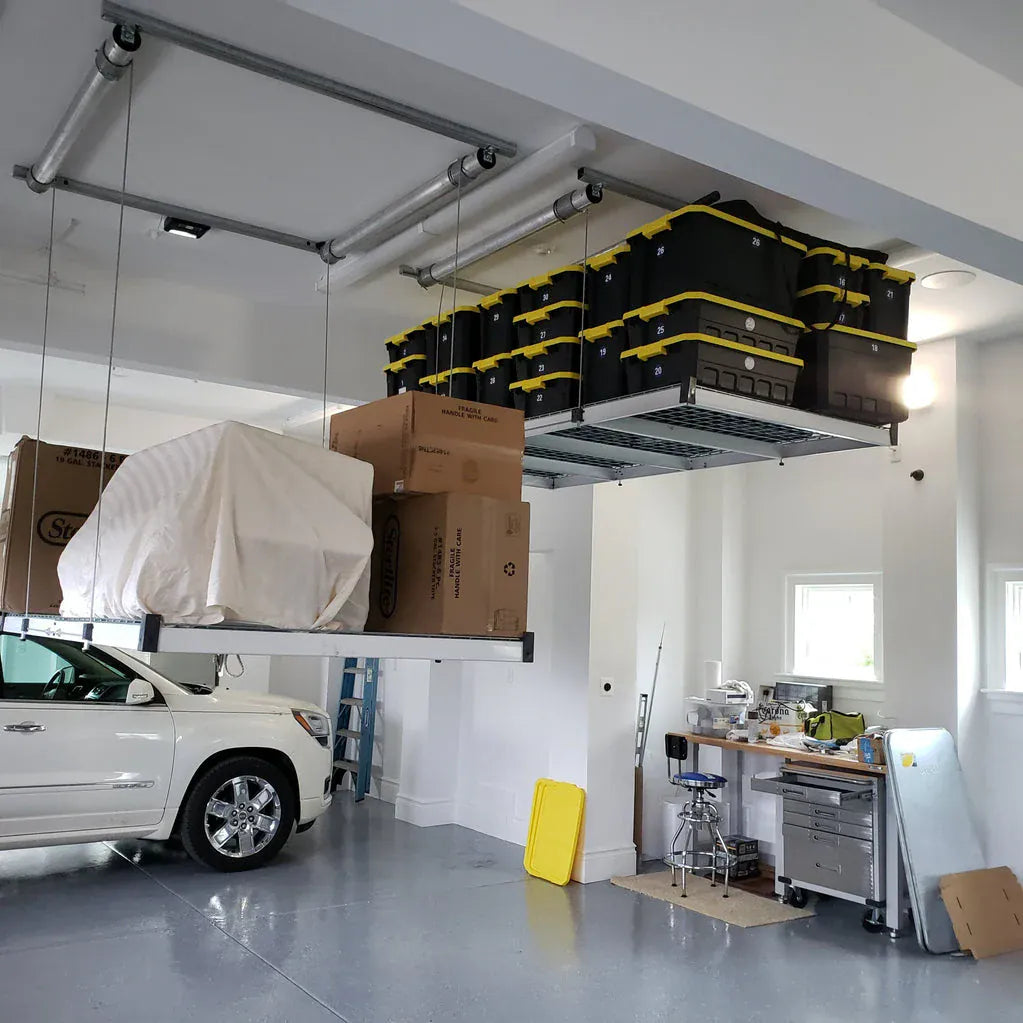 Auxx-Lift platform mounted above a white SUV, loaded with numbered storage totes and boxes