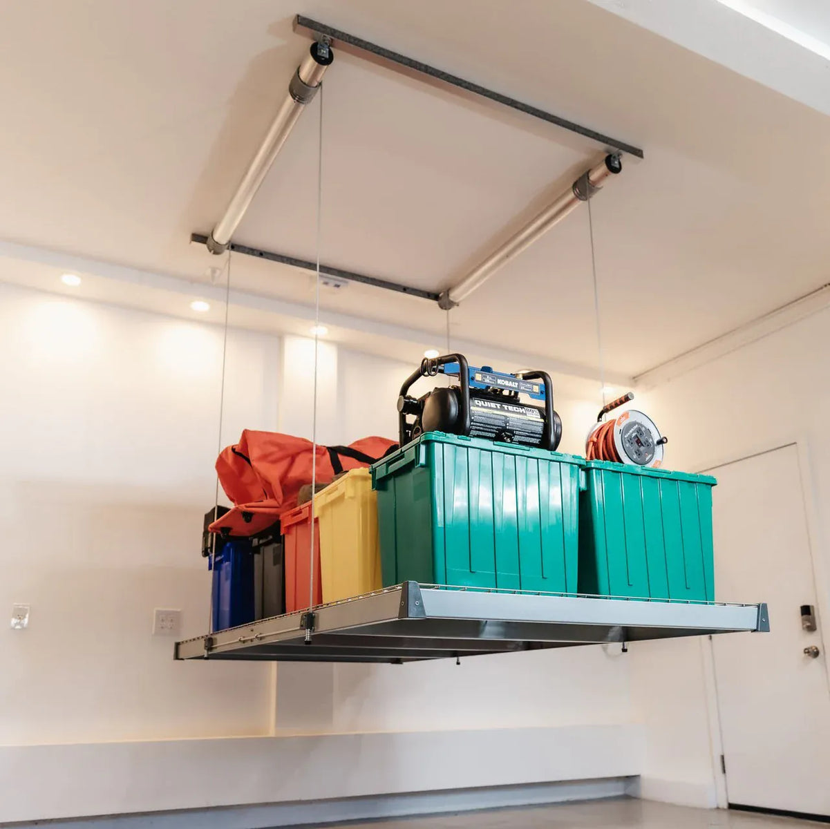 Auxx-Lift platform mounted in a garage corner holding drum shells and storage boxes