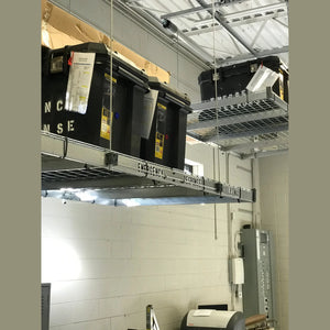 Auxx-Lift platform holding black Emergency Response totes in a cinder-block facility