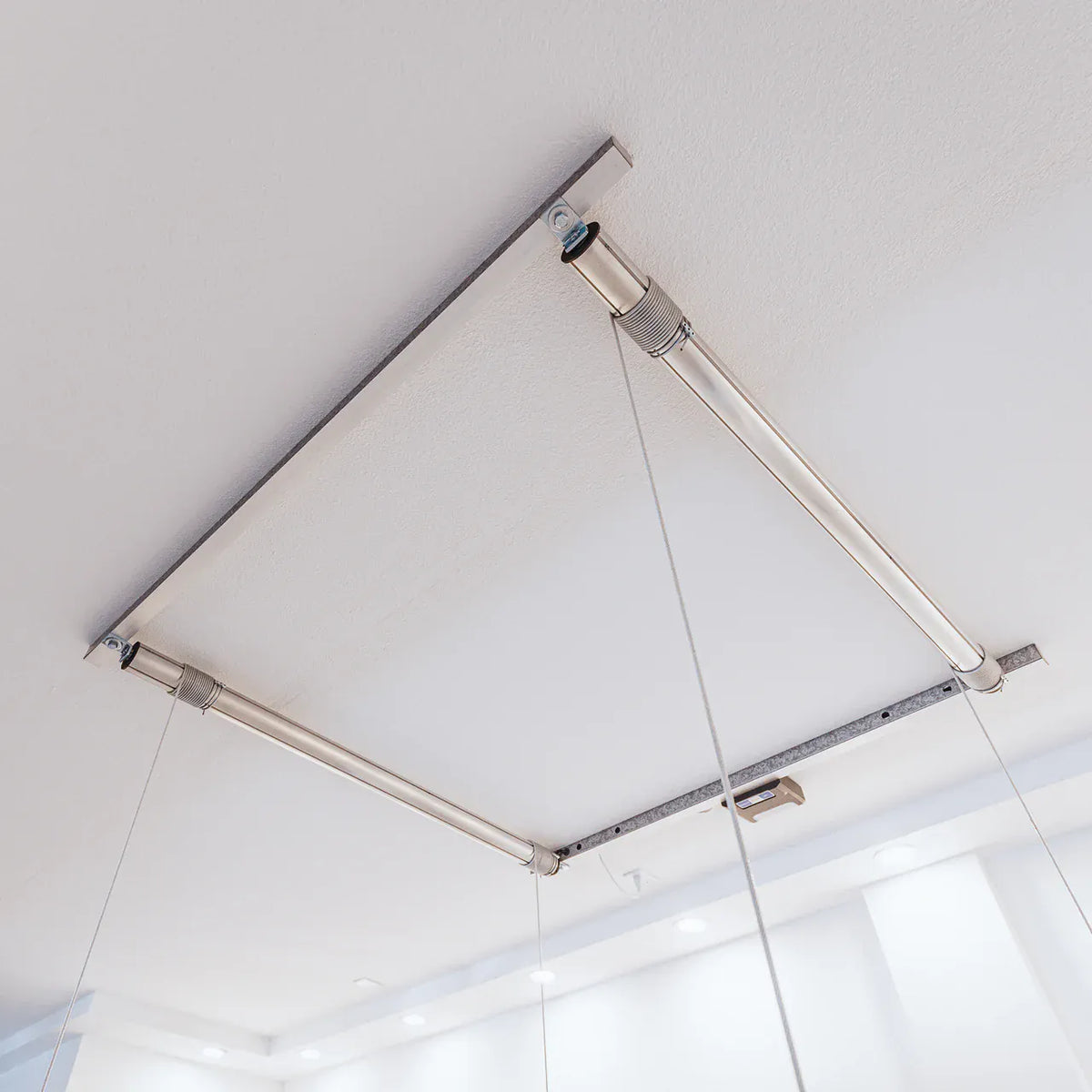 Two Auxx-Lift tubular motors and strut channel mounted to a garage ceiling, cables hanging down