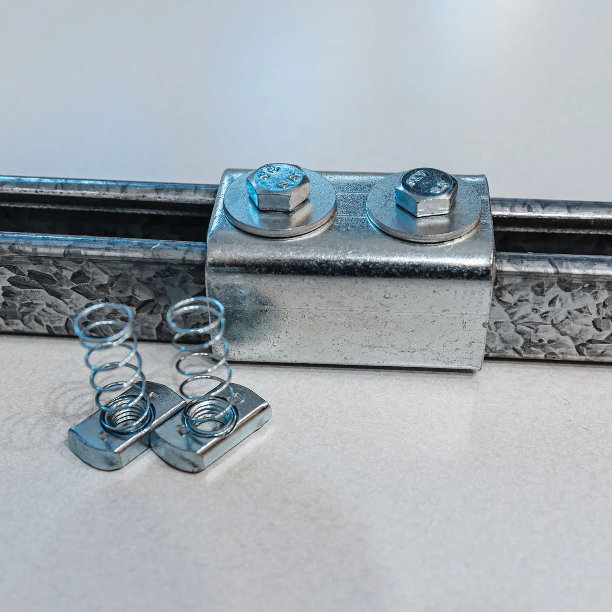 Zinc bracket bolted into galvanized channel rail with spring channel nuts