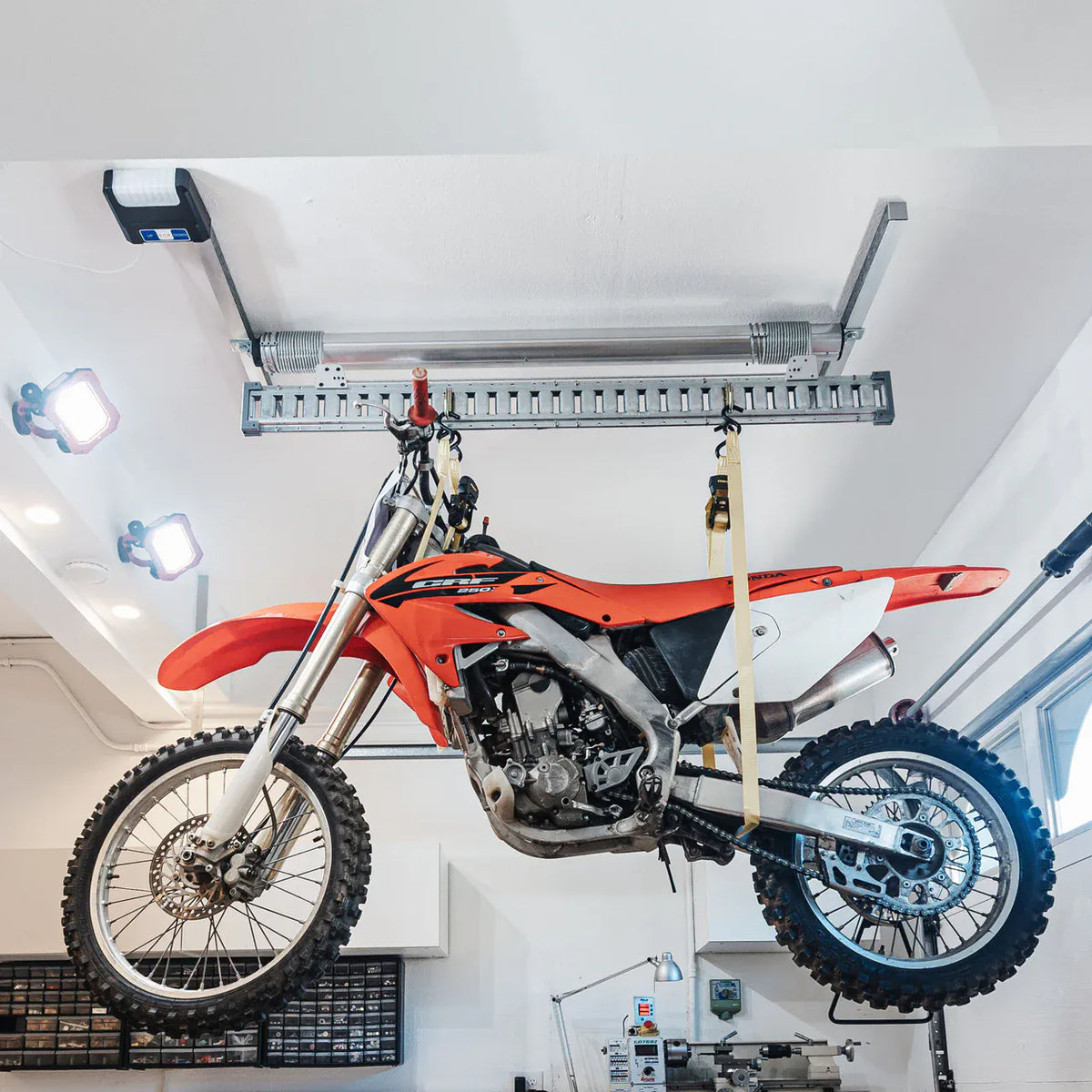 Dirt bike hanging level from the Auxx-One overhead garage lift
