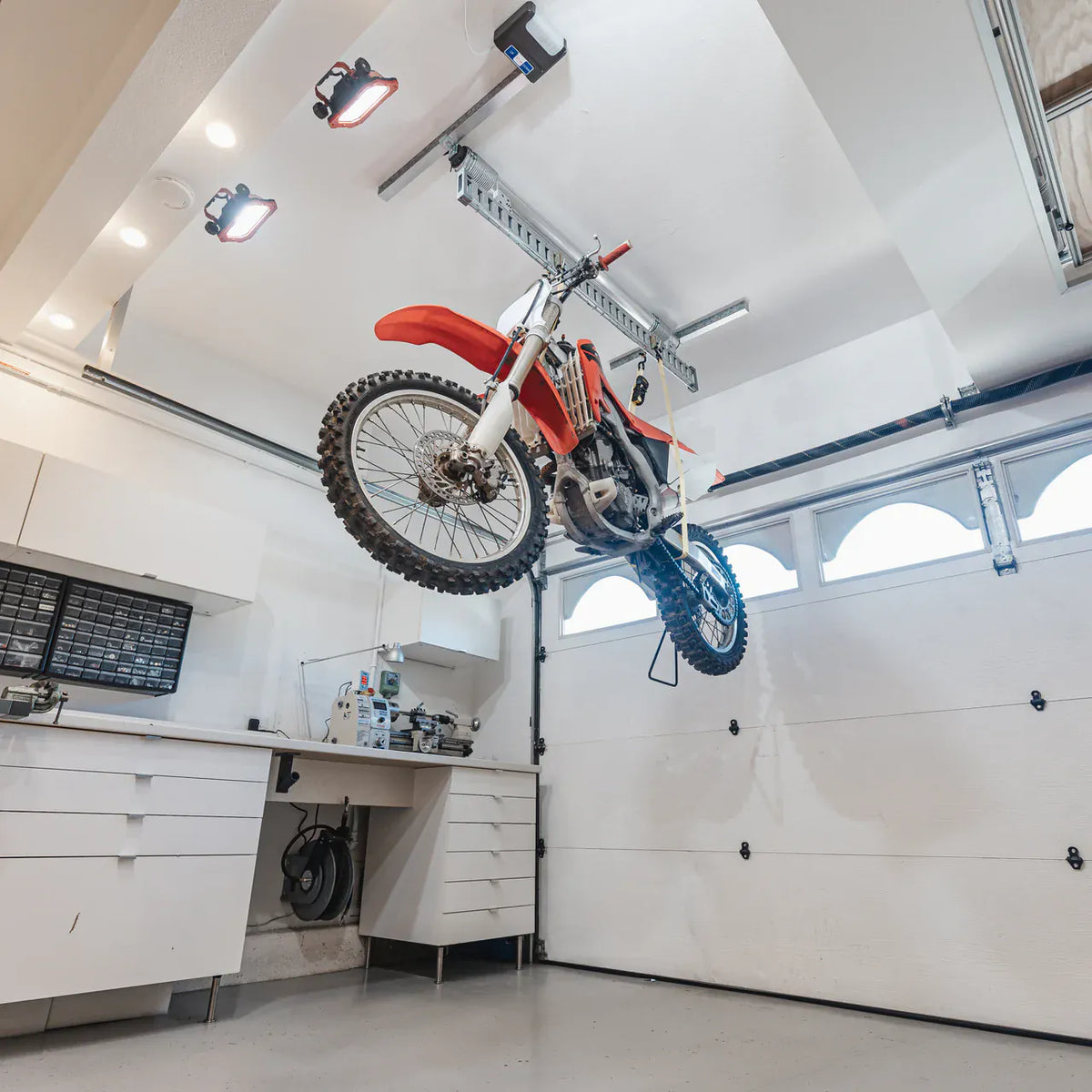 Motorcycle stored against a garage ceiling by the Auxx-One lift