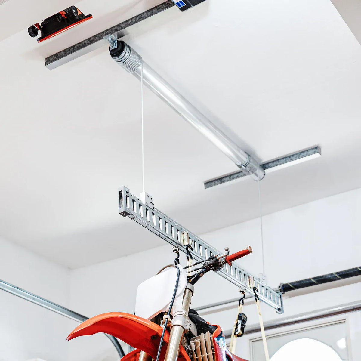 Looking up at the Auxx-One motor, cables, and E-Beam lifting a dirt bike