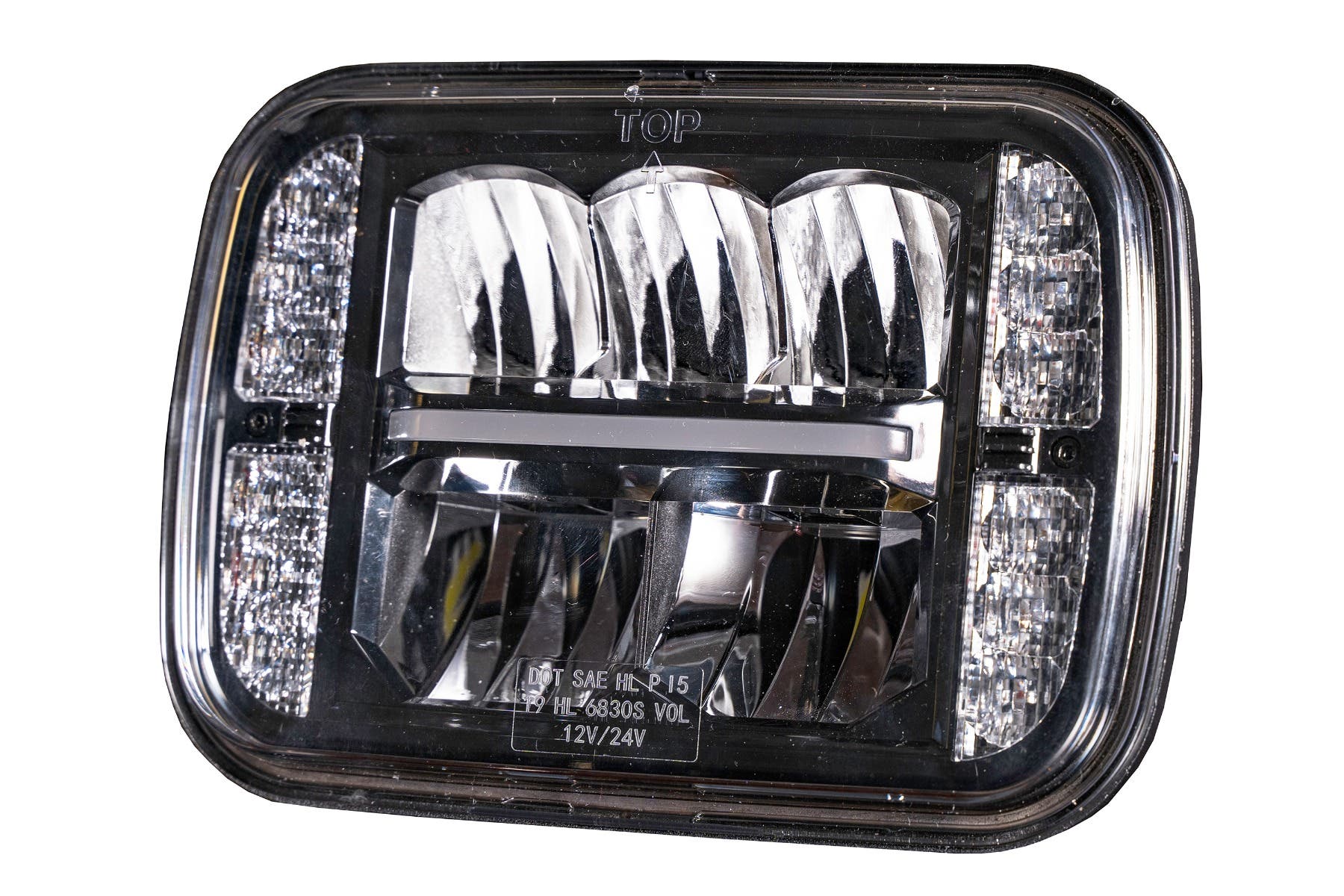 Close-up of an LED light lens marked TOP, DOT SAE HL P15 and 12V/24V