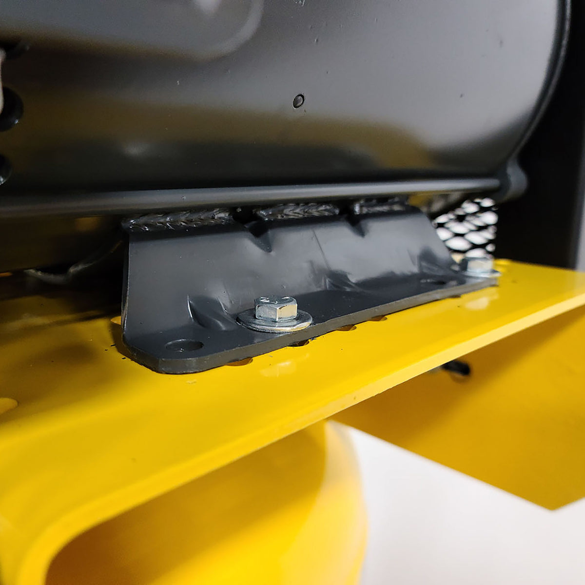 Close-up of a bolted steel mounting bracket on the compressor's yellow tank