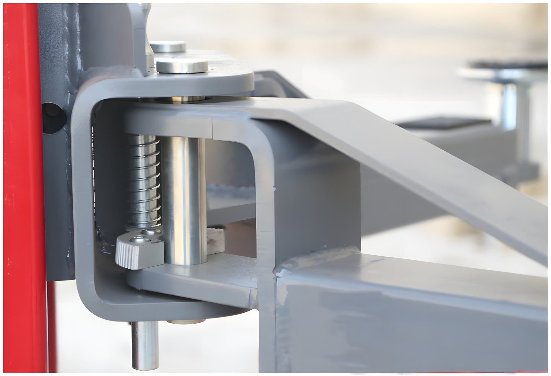 Close-up of the arm restraint pin and spring at the arm pivot
