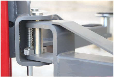 Close-up of the arm restraint pin and spring at the arm pivot