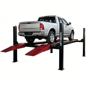 Silver full-size pickup raised on the Katool four-post lift with drive-on ramps