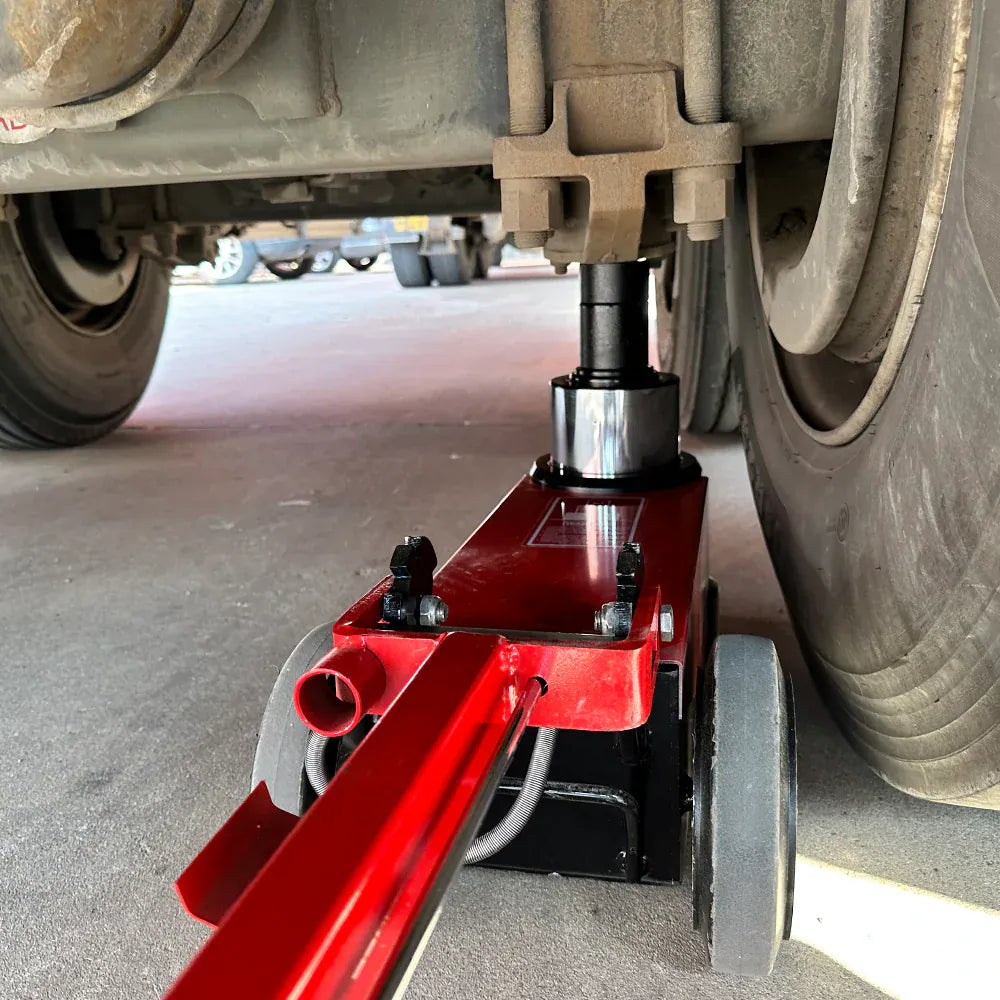 Katool KT-J80T positioned under a heavy truck axle in service