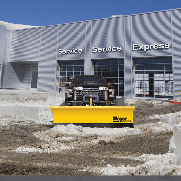Pickup truck with a Meyer WingMan plow clearing slush in front of a service building