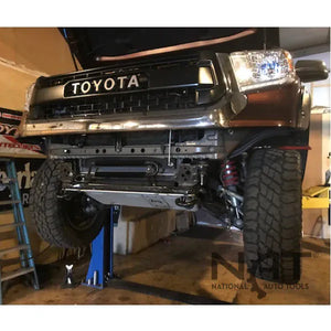 Toyota pickup raised on a two-post lift, front undercarriage and suspension exposed