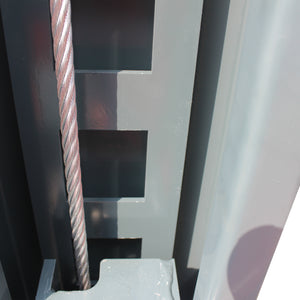 Steel lifting cable running past the slotted safety lock ladder inside a lift post