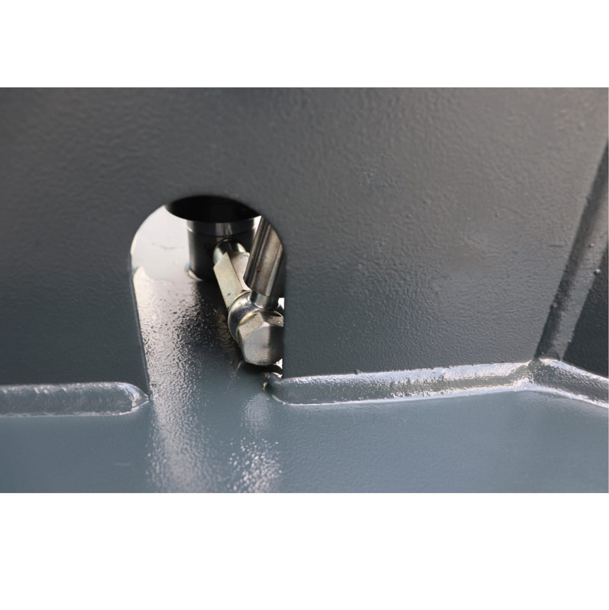Close-up of a steel release-linkage rod at the lift base
