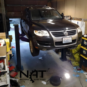 Triumph C7000 portable two-post lift elevating Volkswagen Touareg in a residential garage