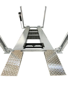 Drive-on view of Triumph NSS-8 X1 four-post lift with aluminum-look approach ramps and central drip trays