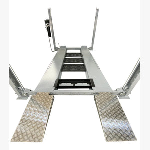 Drive-on view of Triumph NSS-8 X1 four-post lift with aluminum-look approach ramps and central drip trays