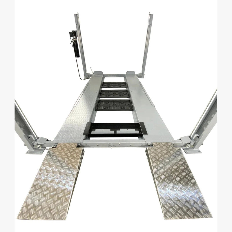 Drive-on view of Triumph NSS-8 X1 four-post lift with aluminum-look approach ramps and central drip trays