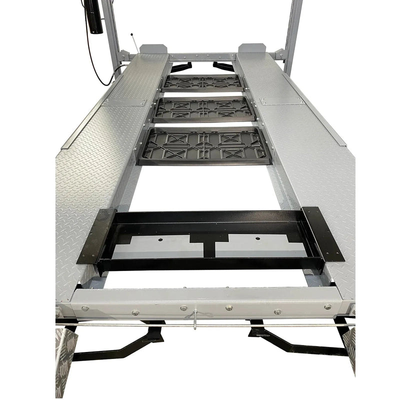 Three drip trays and jack tray installed between four-post lift runways, top-down view