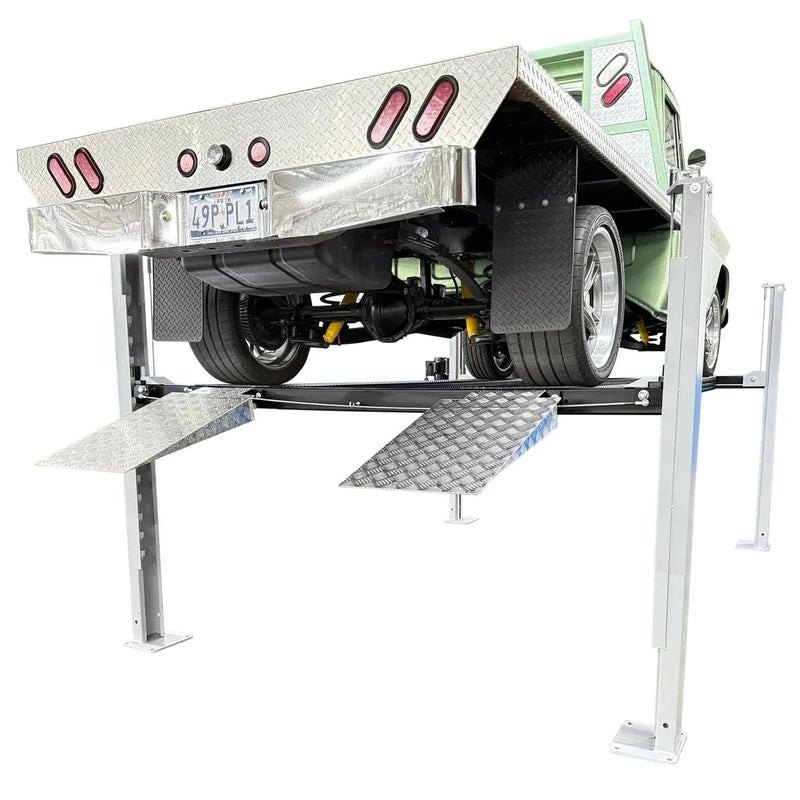 Rear view of the USA8000XLT raised with a green classic pickup, approach ramps and tail lights visible